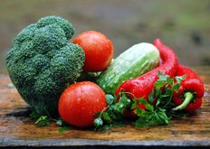 Foto: Tomaten. Paprika und weiteres Gemüse auf einem Holzbrett