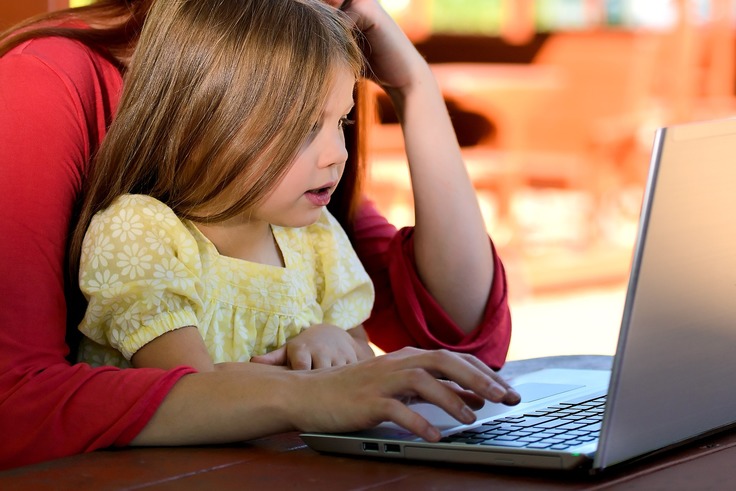 Schmuckgrafik einer Mutter mit ihrem Kind vor einem Laptop